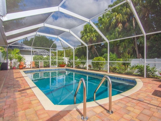 pool with glass enclosure and a patio area