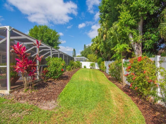 view of yard featuring a fenced backyard and a lanai
