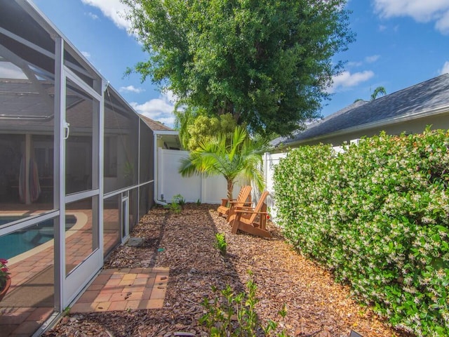 view of yard featuring a fenced backyard and a lanai