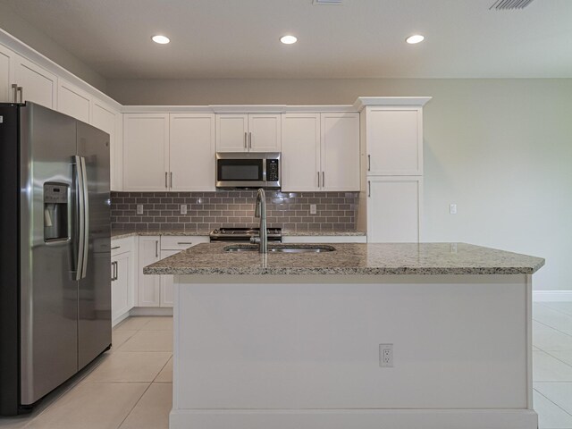 6148 Bella Rosa Ln, Vero Beach, FL 32966 - kitchen featuring light tile patterned floors, light stone counters, white cabinetry, and stainless steel appliances