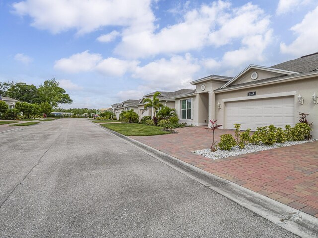 6148 Bella Rosa Ln, Vero Beach, FL 32966 - view of front facade with a garage, stucco siding, and decorative driveway