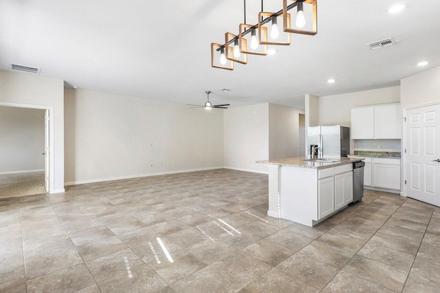 6056 NW Regent St, Port Saint Lucie, FL 34983 - kitchen featuring stainless steel appliances, baseboards, and visible vents