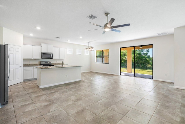 6056 NW Regent St, Port Saint Lucie, FL 34983 - kitchen featuring visible vents, open floor plan, ceiling fan, a sink, and appliances with stainless steel finishes