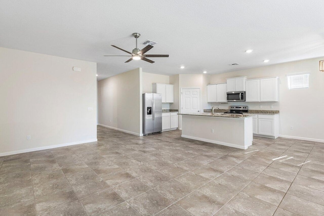 6056 NW Regent St, Port Saint Lucie, FL 34983 - kitchen with appliances with stainless steel finishes, a sink, baseboards, open floor plan, and visible vents