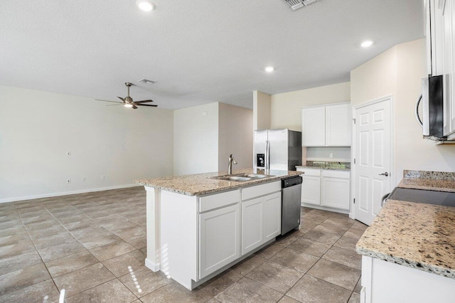 6056 NW Regent St, Port Saint Lucie, FL 34983 - kitchen with ceiling fan, a sink, white cabinets, stainless steel appliances, and an island with sink