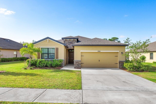 6056 NW Regent St, Port Saint Lucie, FL 34983 - prairie-style house featuring a garage, a front lawn, stucco siding, and stone siding