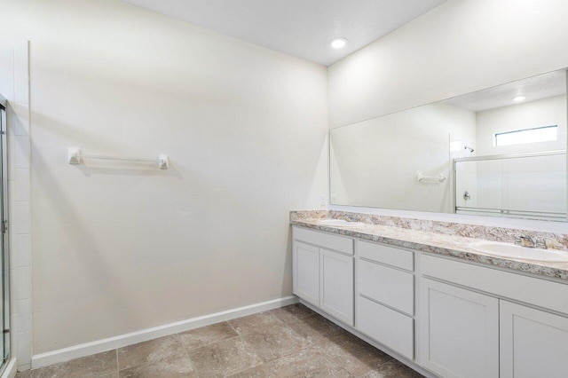 6056 NW Regent St, Port Saint Lucie, FL 34983 - full bathroom with baseboards, double vanity, a shower with door, and a sink