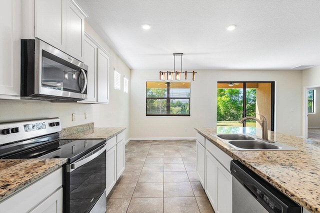6056 NW Regent St, Port Saint Lucie, FL 34983 - kitchen featuring plenty of natural light, a sink, white cabinetry, and stainless steel appliances
