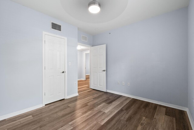 6565 Emerald Dunes Dr Unit 108, West Palm Beach, FL 33411 - unfurnished bedroom with visible vents, baseboards, and wood finished floors