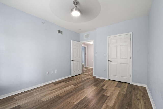 6565 Emerald Dunes Dr Unit 108, West Palm Beach, FL 33411 - unfurnished bedroom featuring baseboards, a ceiling fan, wood finished floors, and visible vents