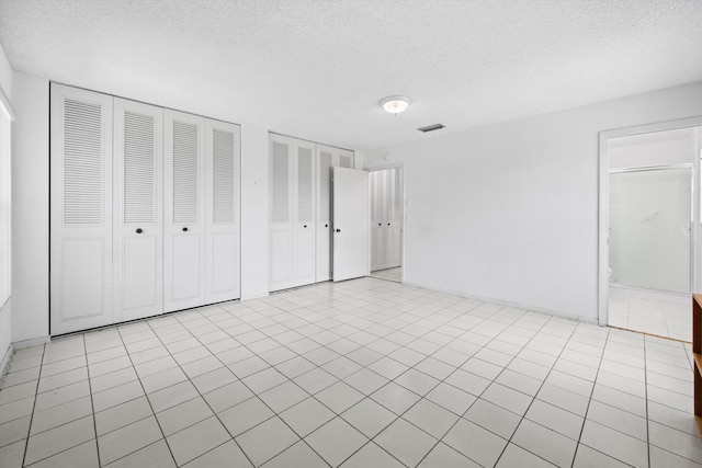 208 Cape Cod Cir, Lake Worth, FL 33467 - unfurnished bedroom featuring a textured ceiling and multiple closets