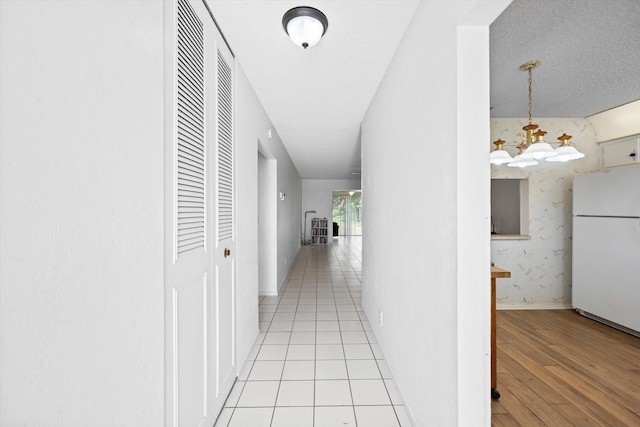 208 Cape Cod Cir, Lake Worth, FL 33467 - hallway with light wood finished floors, a chandelier, and baseboards