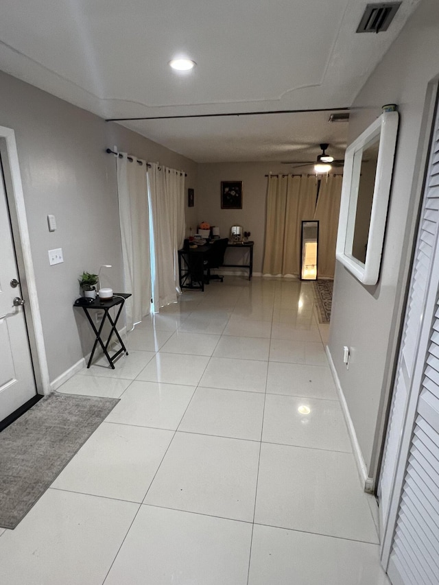 hallway featuring light tile patterned floors, visible vents, recessed lighting, and baseboards