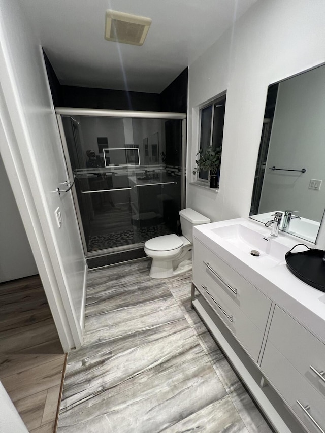 full bathroom with visible vents, vanity, toilet, and a shower stall