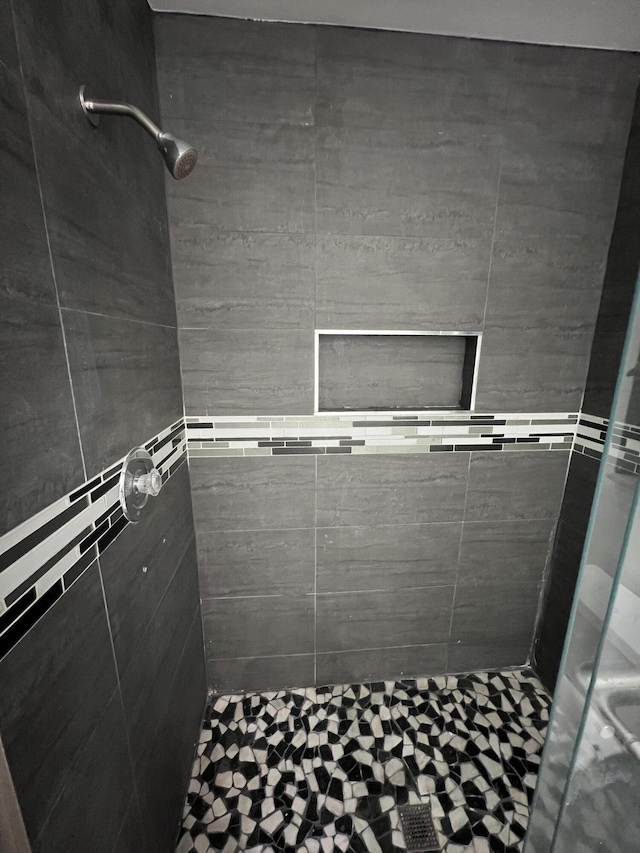 full bath with a tile shower