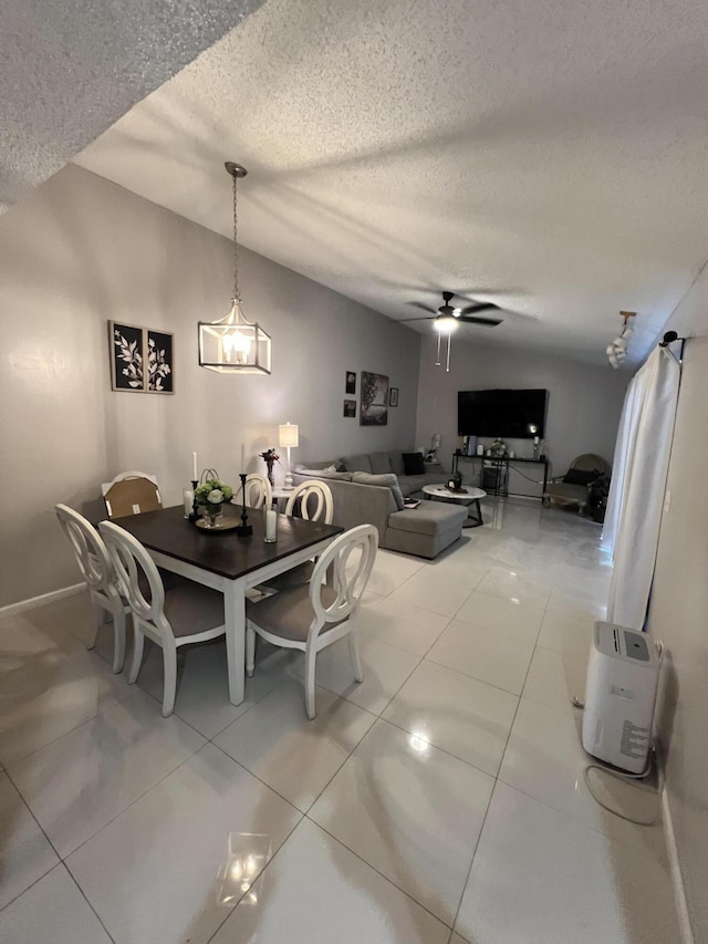 dining space with baseboards, light tile patterned floors, a ceiling fan, and a textured ceiling