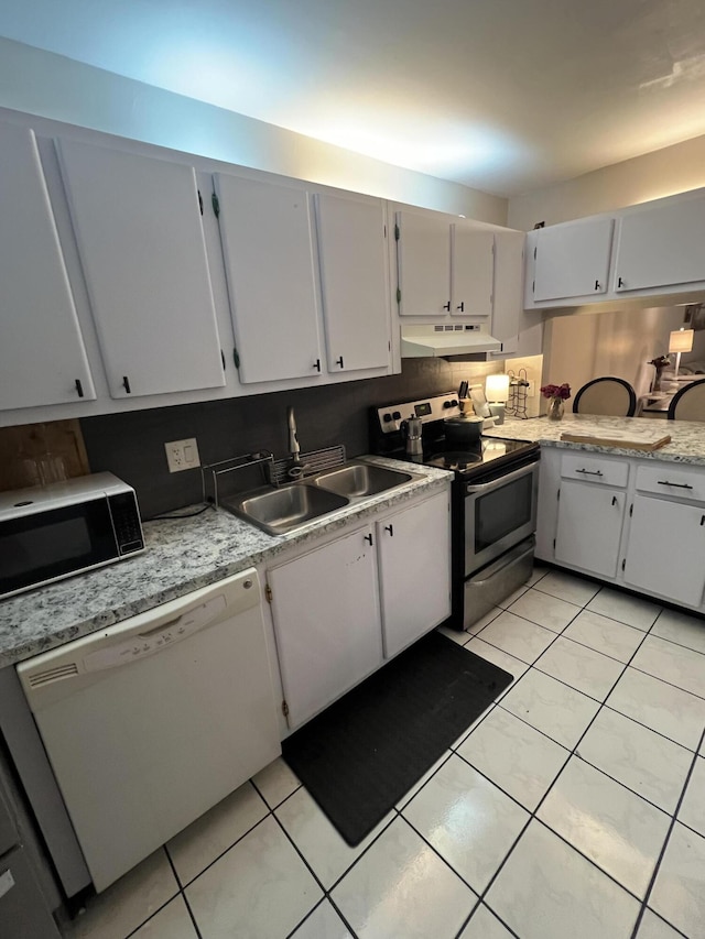 kitchen with light tile patterned floors, a sink, stainless steel appliances, light countertops, and under cabinet range hood
