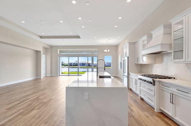 kitchen featuring light wood-type flooring, a sink, stainless steel appliances, recessed lighting, and an island with sink