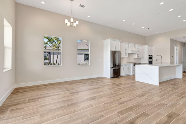 kitchen featuring white cabinets, recessed lighting, appliances with stainless steel finishes, and custom exhaust hood