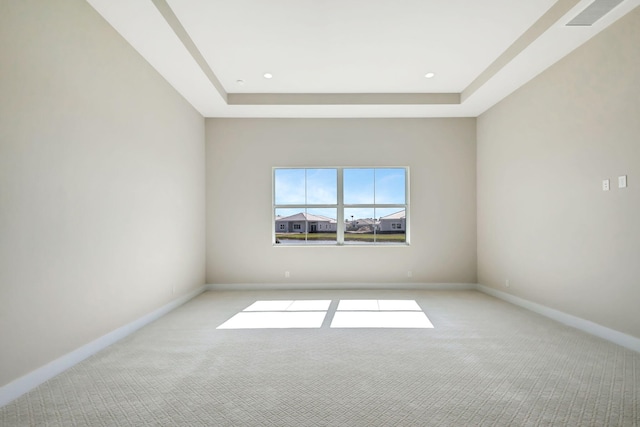 carpeted empty room with visible vents, recessed lighting, a raised ceiling, and baseboards