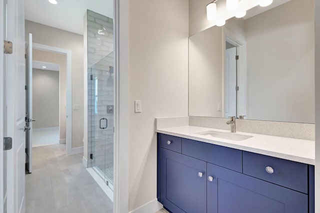 full bath featuring vanity, baseboards, and a stall shower