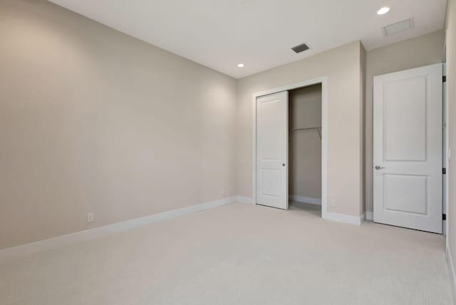 unfurnished bedroom featuring light colored carpet, recessed lighting, baseboards, visible vents, and a closet
