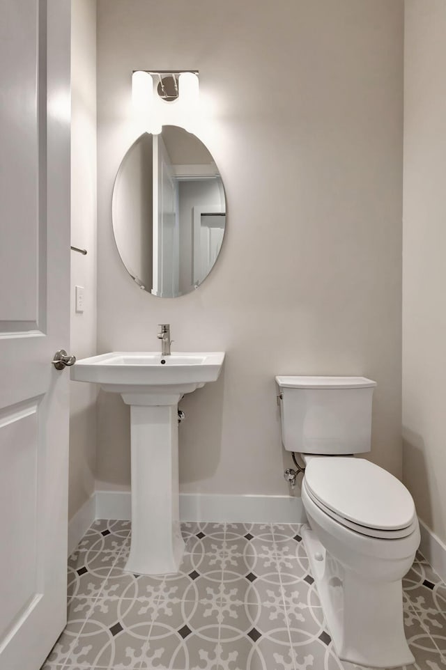 bathroom featuring baseboards and toilet