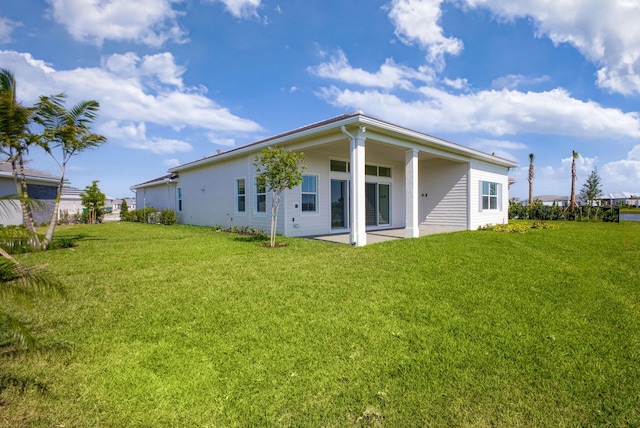 rear view of property with a patio and a lawn