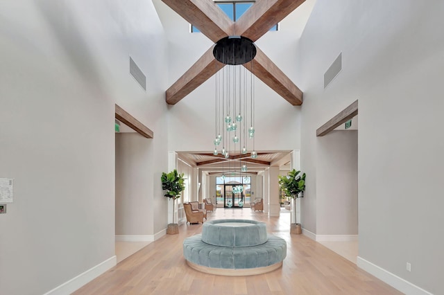 foyer featuring visible vents, a towering ceiling, and wood finished floors