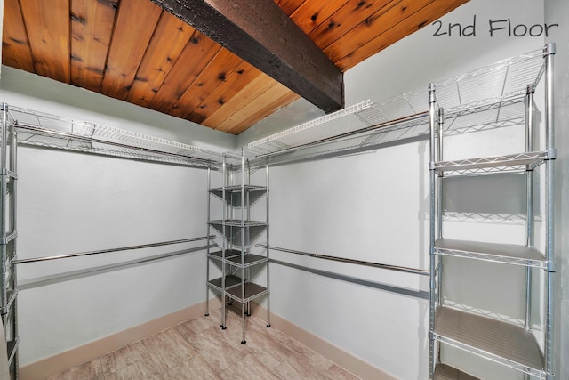 walk in closet featuring beamed ceiling