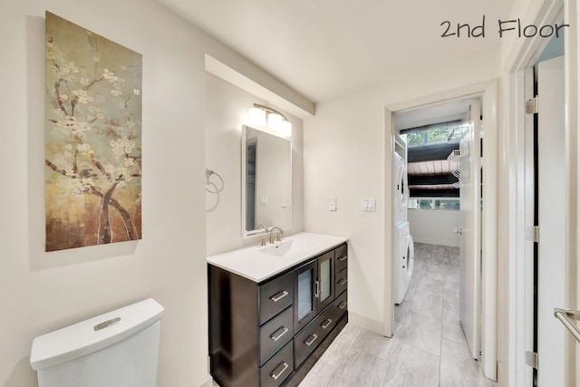 bathroom with toilet, baseboards, and vanity