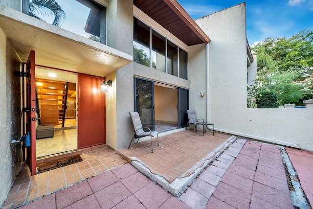 rear view of house featuring a patio and stucco siding
