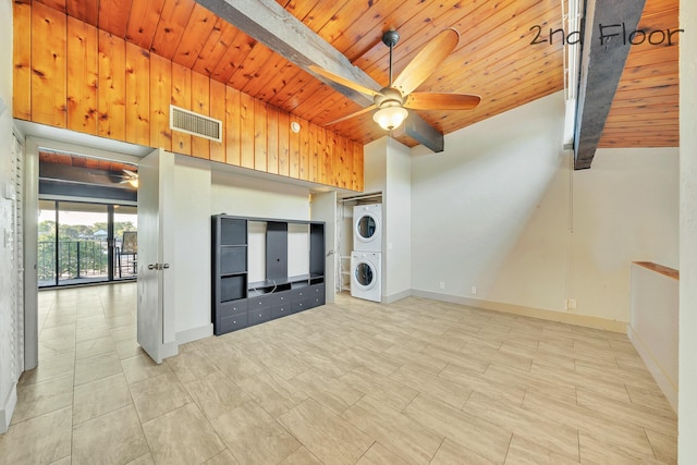 unfurnished living room featuring stacked washer and dryer, visible vents, wooden ceiling, a ceiling fan, and baseboards