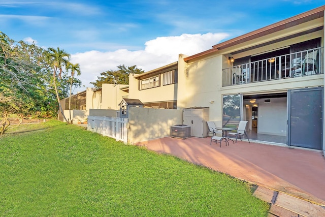 back of property featuring a yard, stucco siding, fence, and a patio
