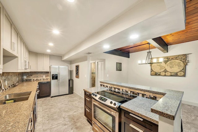 kitchen with recessed lighting, dark brown cabinets, a sink, stainless steel appliances, and tasteful backsplash