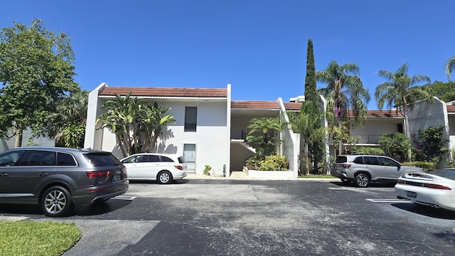 1823 Embassy Dr Unit 101, West Palm Beach, FL 33401 - exterior space with uncovered parking, stucco siding, and a tile roof