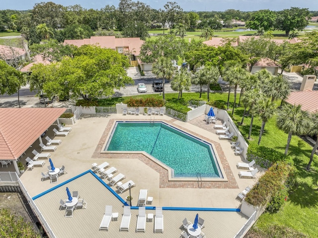 community pool featuring fence, a patio, and a residential view
