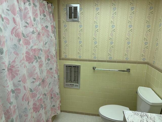 331 Tequesta Dr Unit 212, Tequesta, FL 33469 - bathroom with tile walls, vanity, toilet, wainscoting, and tile patterned flooring