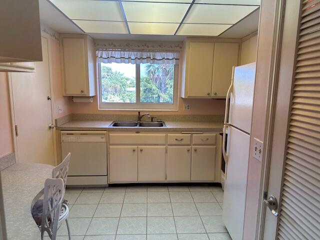 331 Tequesta Dr Unit 212, Tequesta, FL 33469 - kitchen with white appliances, a sink, light countertops, light tile patterned floors, and cream cabinets