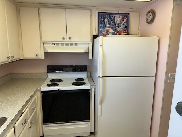 331 Tequesta Dr Unit 212, Tequesta, FL 33469 - kitchen featuring white appliances, under cabinet range hood, light countertops, and white cabinets
