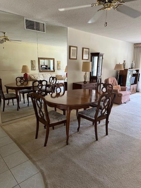 331 Tequesta Dr Unit 212, Tequesta, FL 33469 - dining area with ceiling fan, a textured ceiling, light carpet, and light tile patterned floors