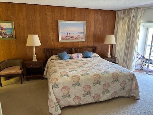 331 Tequesta Dr Unit 212, Tequesta, FL 33469 - bedroom with carpet flooring, access to exterior, and wood walls