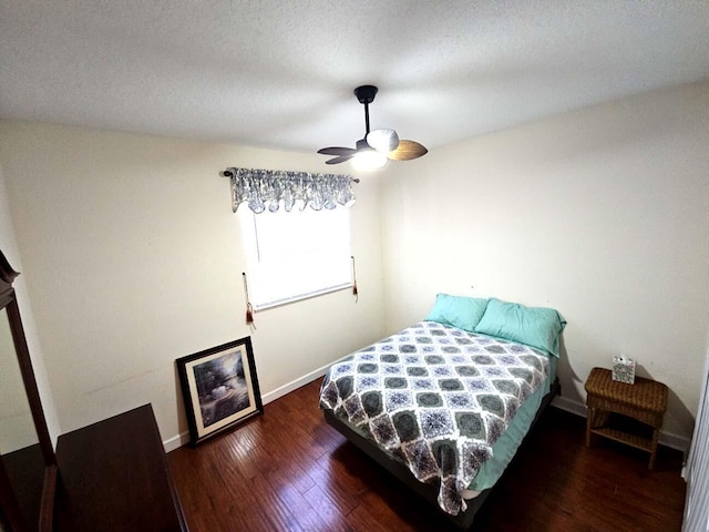 bedroom featuring baseboards, wood finished floors, and a ceiling fan