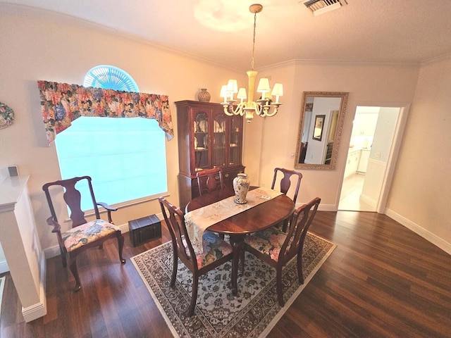 dining room featuring visible vents, baseboards, ornamental molding, wood finished floors, and a notable chandelier