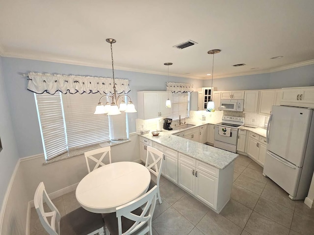 kitchen with a sink, visible vents, white appliances, a peninsula, and hanging light fixtures