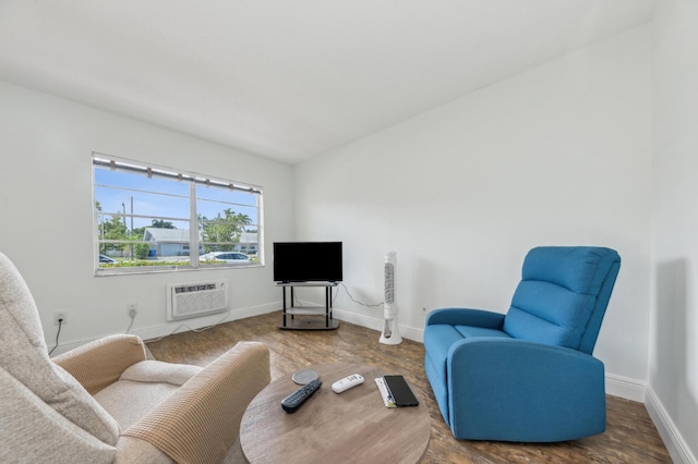 living area featuring baseboards, a wall mounted AC, and wood finished floors