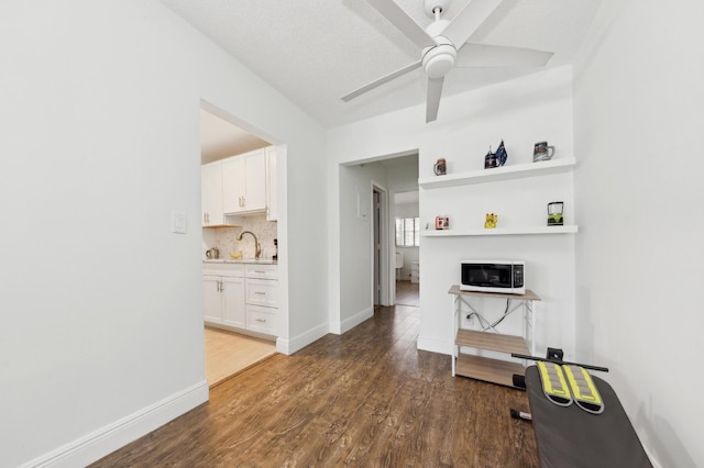 interior space with baseboards, a sink, and wood finished floors