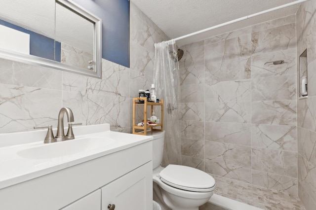 bathroom featuring a textured ceiling, tile walls, vanity, toilet, and tiled shower