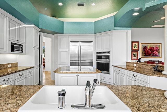 16330 Vintage Oaks Ln, Delray Beach, FL 33484 - kitchen featuring built in appliances, white cabinets, dark stone counters, and recessed lighting
