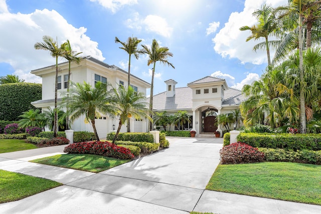 16330 Vintage Oaks Ln, Delray Beach, FL 33484 - mediterranean / spanish home featuring curved driveway, a front yard, stucco siding, and an attached garage